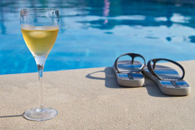 White wine glass by swimming pool